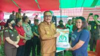 Penjabat Bupati Ir. Limi Mokodompit, MM saat menyerahkan beras secara simbolis (ist)