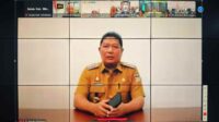 Penjabat Bupati Minahasa Dr. Jemmy Stani Kumendong M,Si saat mengikuti rapat koordinasi pengendalian inflasi daerah secara online (ist)