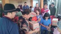 Penjabat Bupati Minahasa Dr. Jemmy Stani Kumendong M,Si, saat menyerahkan bantuan (ist)