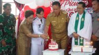 Bupati Minahasa Selatan, Franky Donny Wongkar, SH saat memasang lilin bersama Camat Motoling Timur (ist)