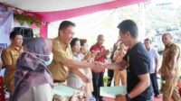 Bupati Minahasa Selatan, Franky Donny Wongkar, SH saat menyerahkan Sertipikat Tanah Program PTSL di Desa Picuan (ist)