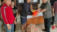 Penjabat Bupati Minahasa Dr. Jemmy Stani Kumendong M,Si, saat menyerahkan bantuan (ist)