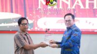 Penjabat Bupati Minahasa saat menerima penghargaan (ist)